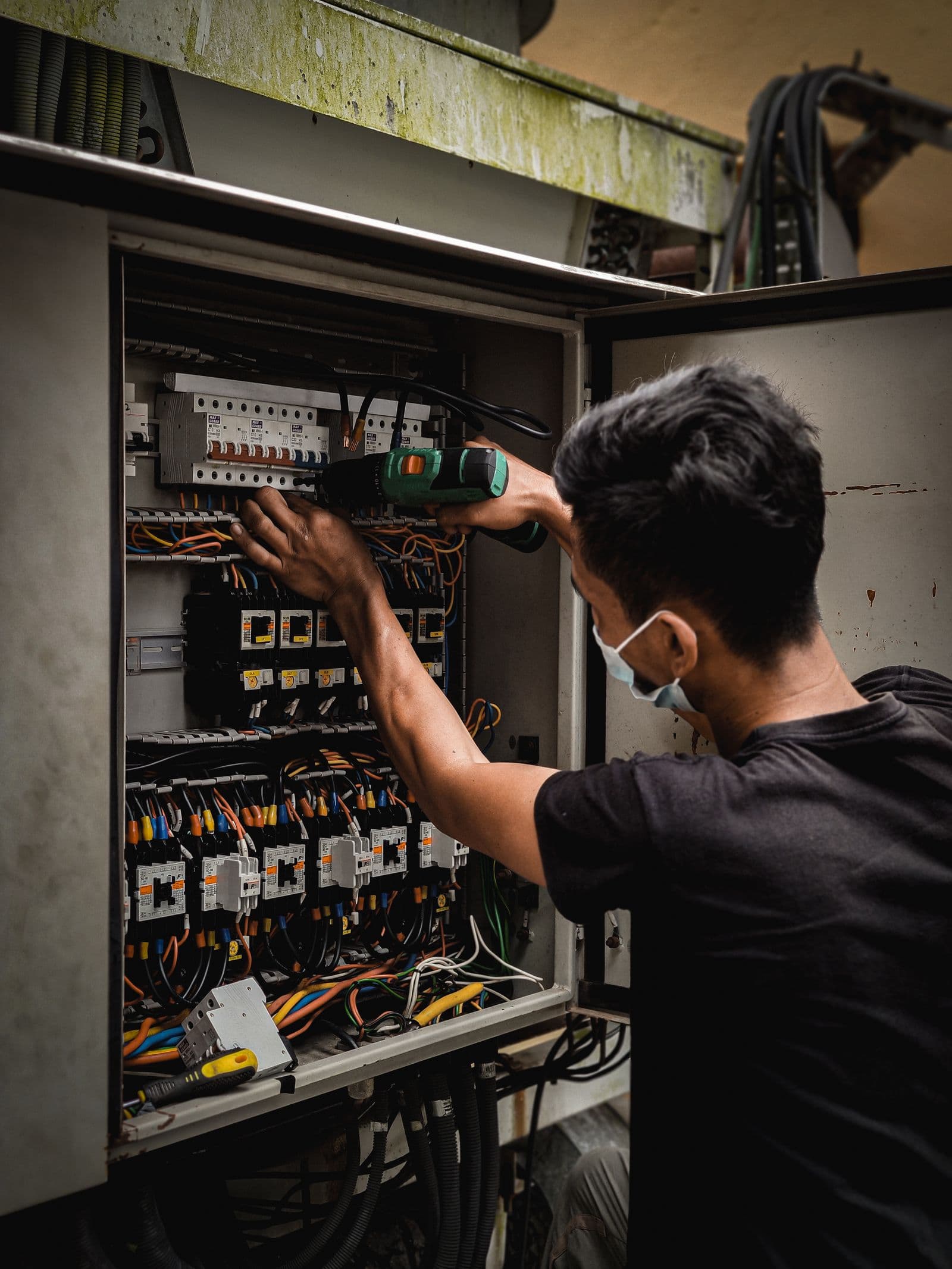 Mano che riarma un interruttore differenziale salvavita nel quadro elettrico